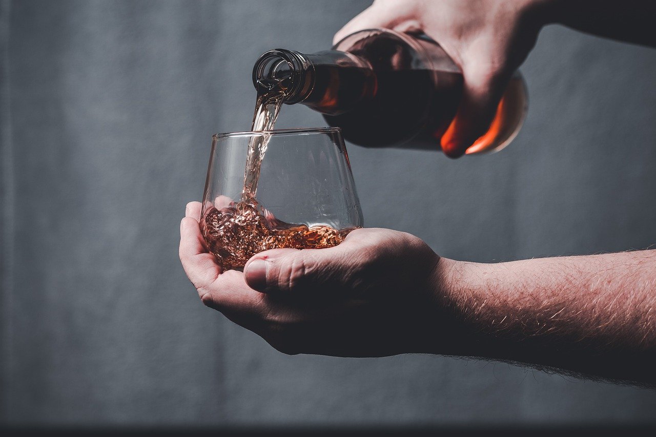 Whiskey being poured into a glass, captured in motion. One of the many things to experience on your Bourbon Tour.